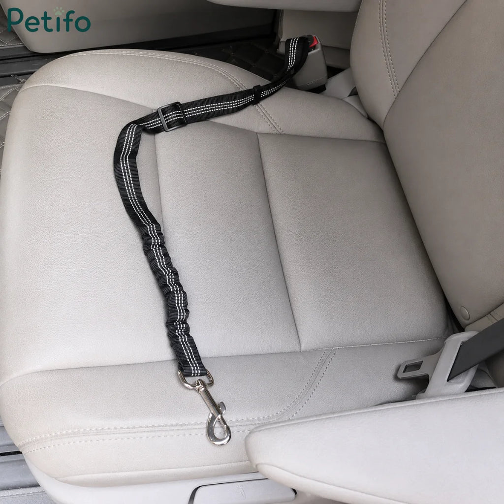 Black bungee-style Petifo pet seat belt resting on a beige leather car seat ready for use.