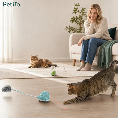 Happy woman on a couch watching two cats play with blue and green Petifo interactive cat toys