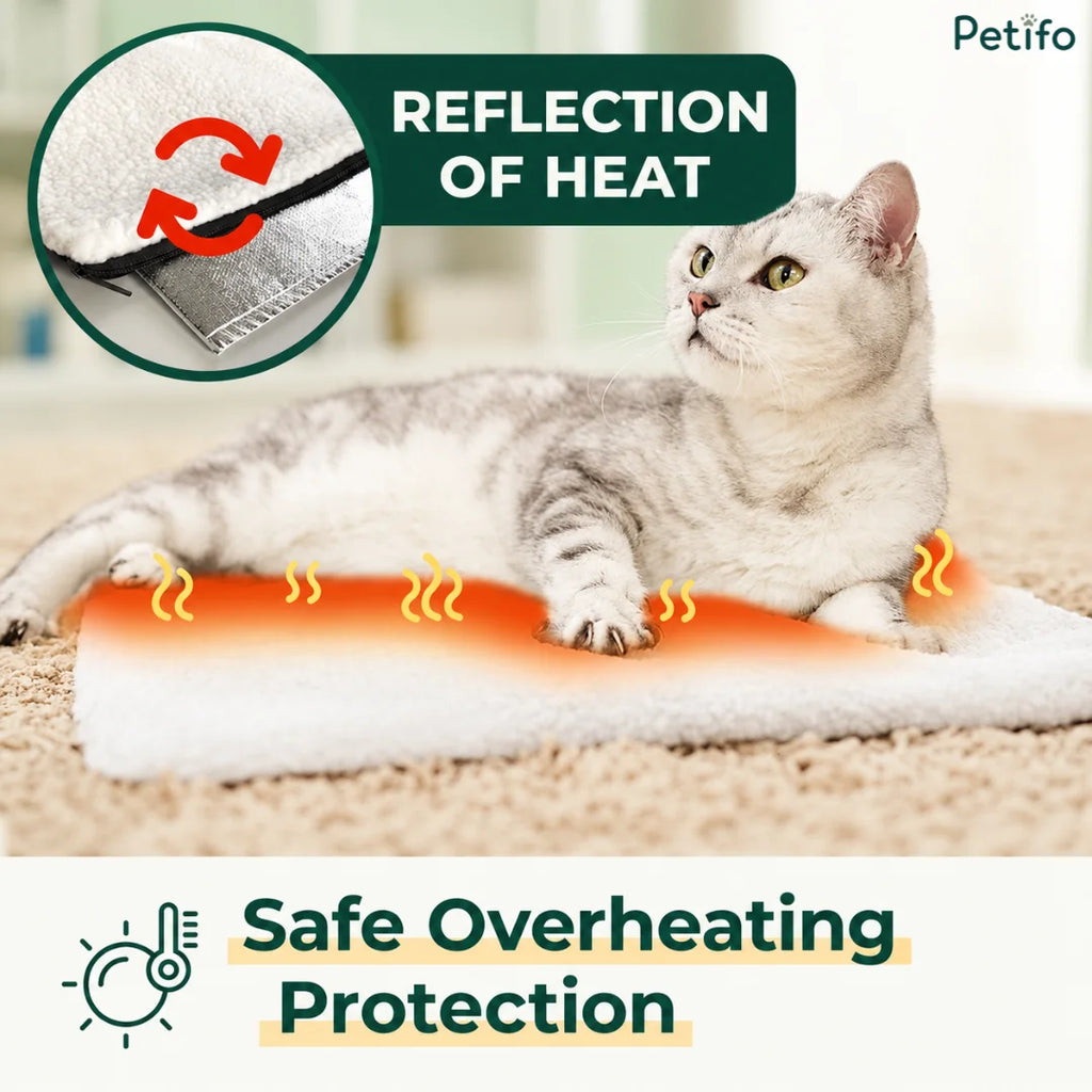A light grey tabby cat lying comfortably on a self-warming pet mat, with a circular inset highlighting the internal silver reflective heat layer and red cyclical arrows.