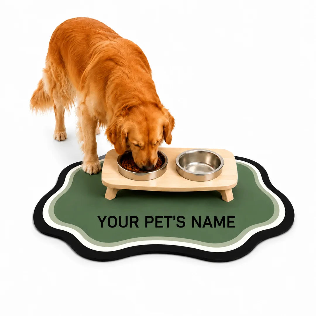 Golden retriever eating from a raised stainless steel bowl set on a personalized green custom name pet mat.