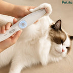 Person gently trimming the paw fur of a relaxed white cat using the handheld pet hair trimmer.