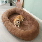 A cute corgi resting comfortably inside a large, plush brown human dog bed.