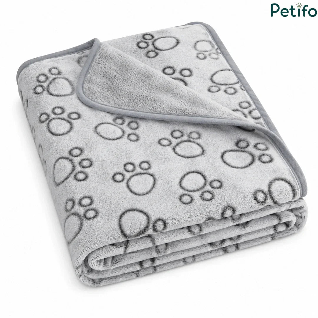 Folded grey fleece puppy blanket featuring a cute paw print pattern and smooth piped edging.