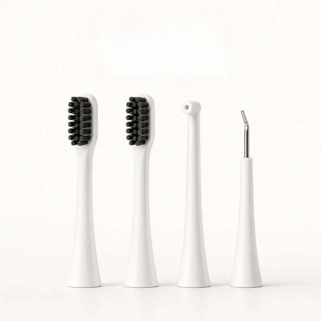 Four white replacement attachment heads for a dog electric toothbrush including two brush heads, a water flosser nozzle, and a scraper.