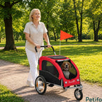 Woman comfortably walking on a park path while pushing the Petifo red pet stroller with a beagle inside.